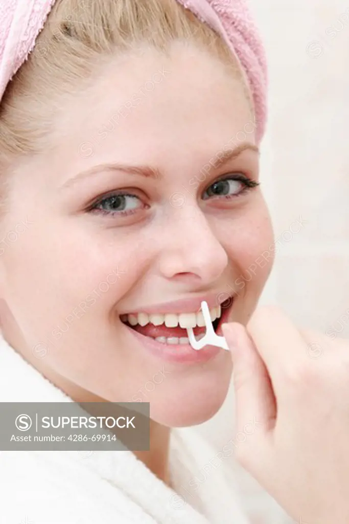 Young woman cleans to herself the teeth with dental floss