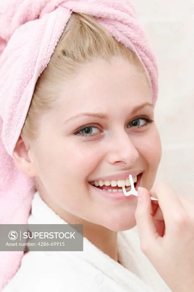 Young woman cleans to herself the teeth with dental floss; Young woman cleans to herself the teeth with dental flowed