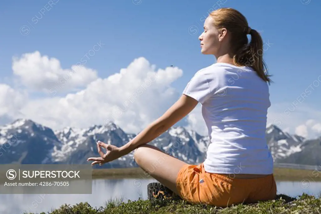 Young woman meditating in the mountains.