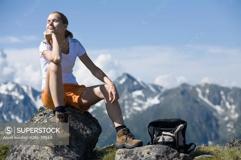 Young pretty woman having rest in the mountains.