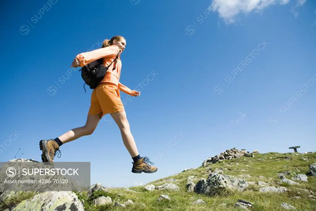 Young pretty woman trekking in the mountains.