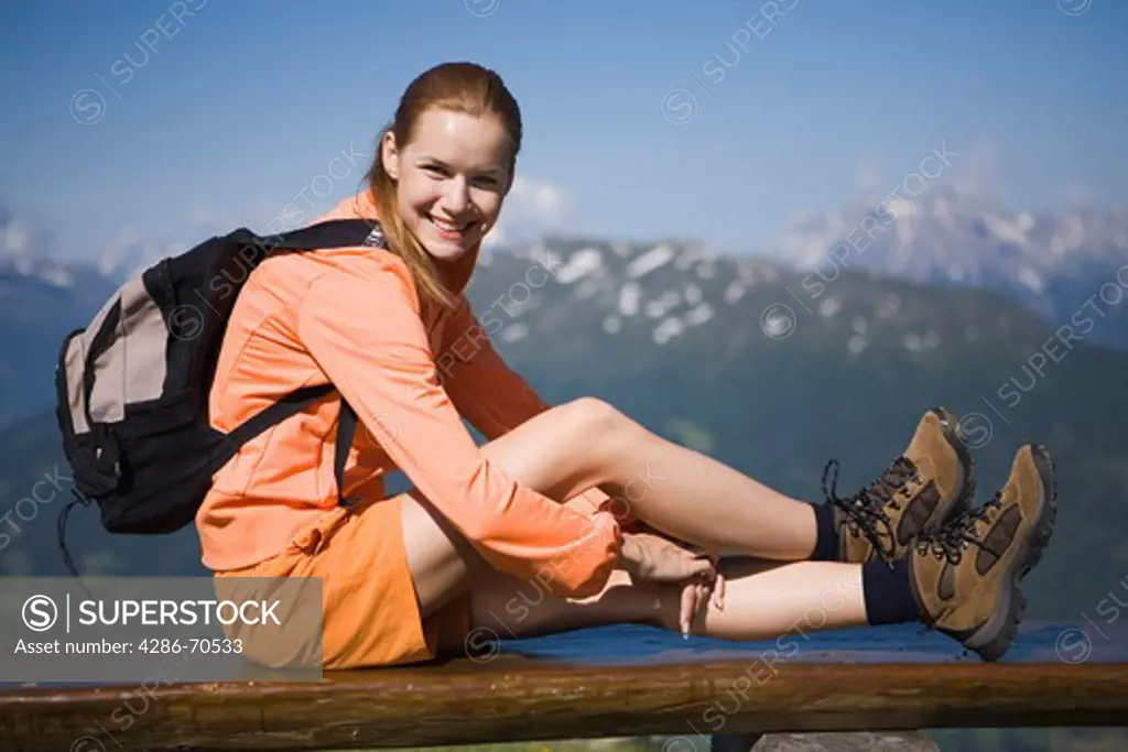 Pretty young woman trekking in the mountains and having rest.