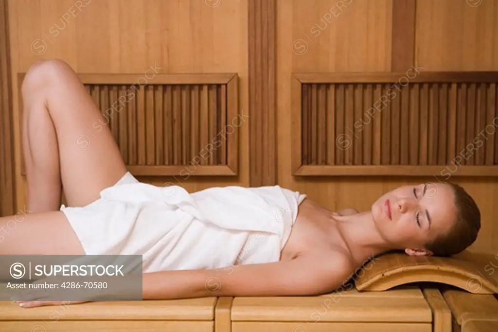 Young woman relaxing in sauna.