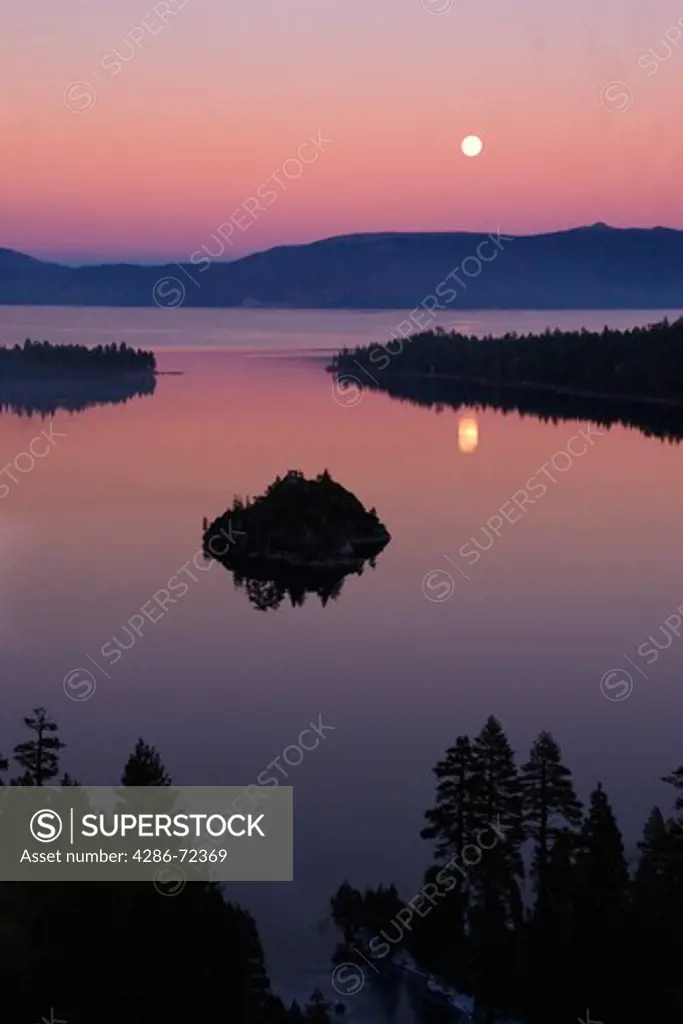 The full moon rising over Emerald Bay at sunset with alpenglow at Lake Tahoe California