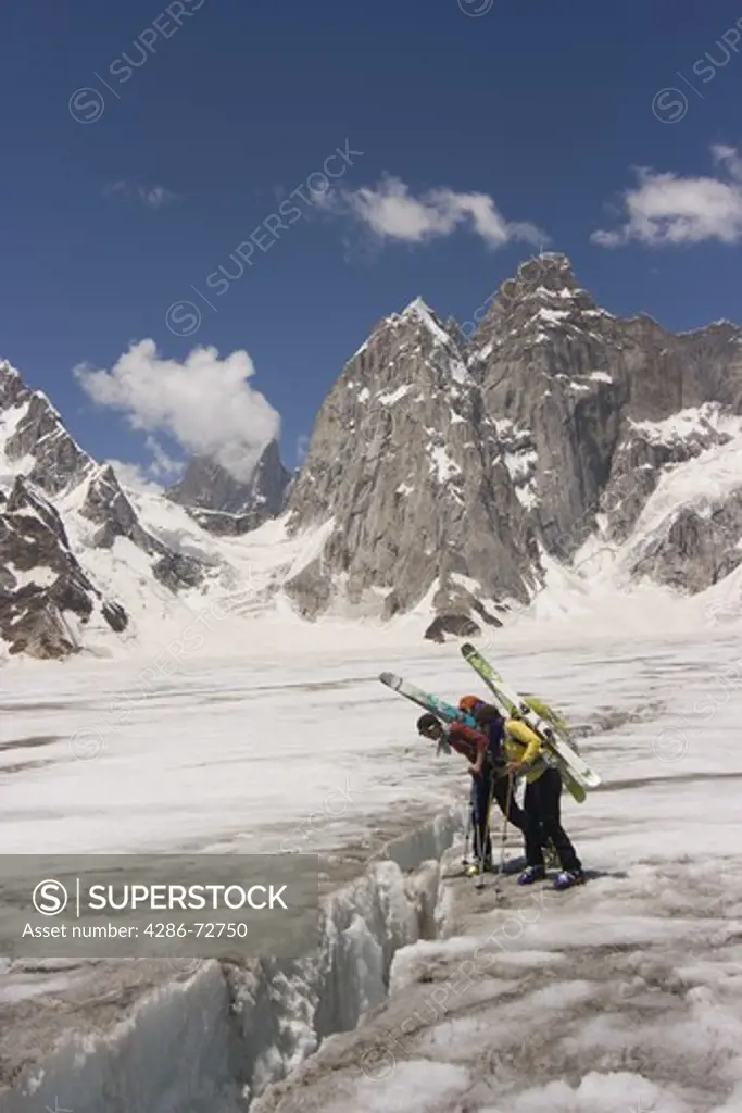  Two women ski mountaineers looking into a crevasse on the Biafo glacier in the Karakoram mountains of Pakistan