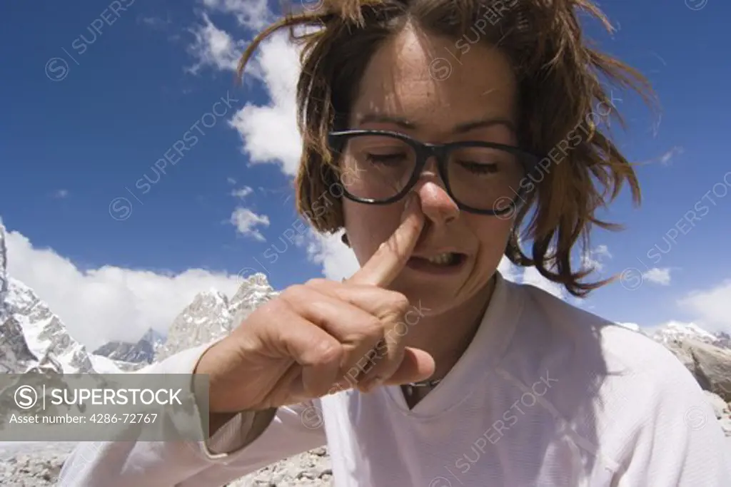  A woman picking and blowing her nose
