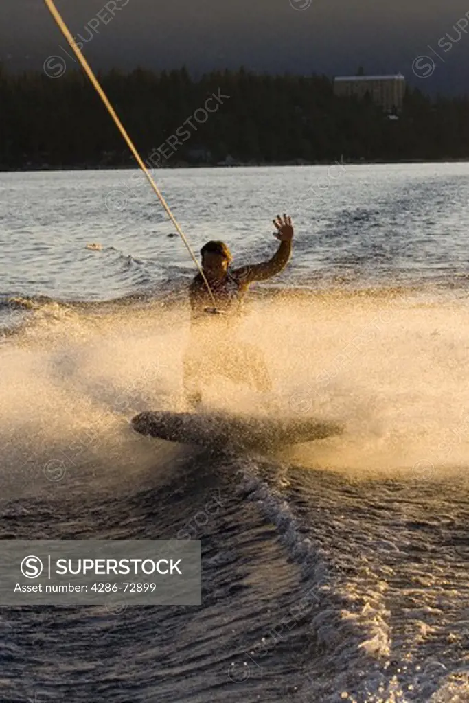  A man wakeboarding at sunrise on Lake Tahoe in California