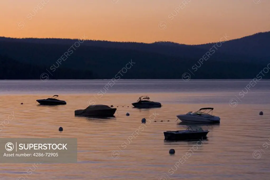 Silhouettes of power boats on Lake Tahoe at sunset