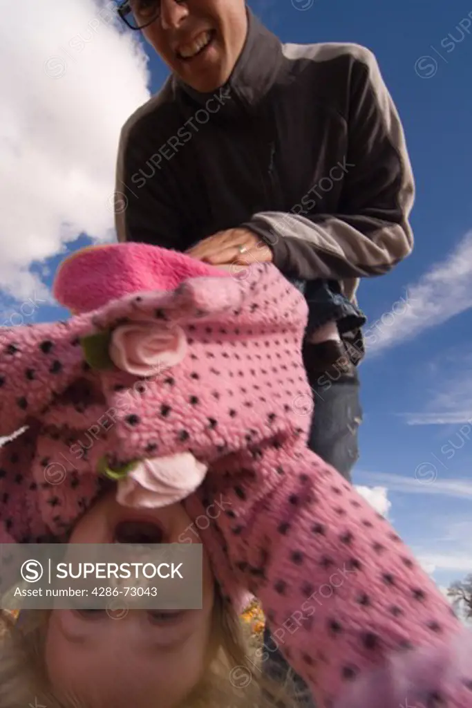  A father swinging his child in a pumpkin patch in Fallon Nevada