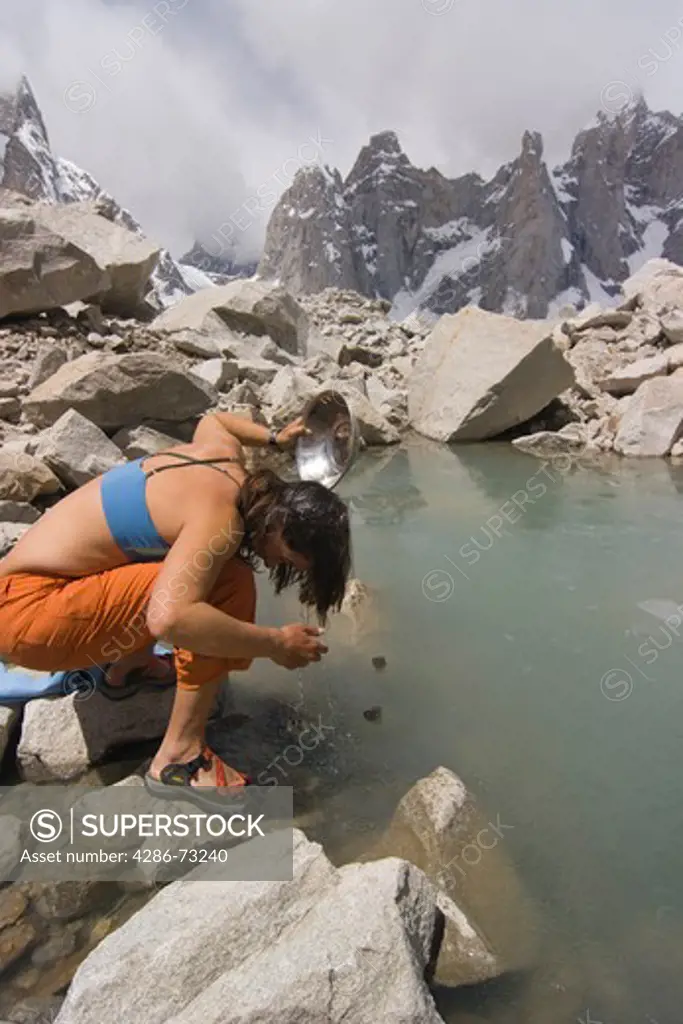 A woman washing her hair in a pond on the Biafo Glacier in Baltistan in Pakistan