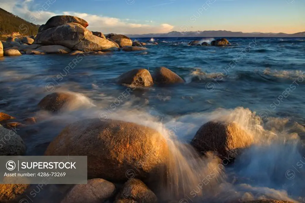  A blurry photo of a rocky shoreline on the east shore of Lake Tahoe at sunset
