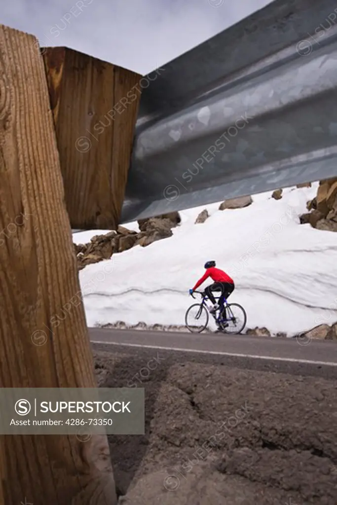  A man climbing uphill on a bicyle in winter on Donner Summit in California