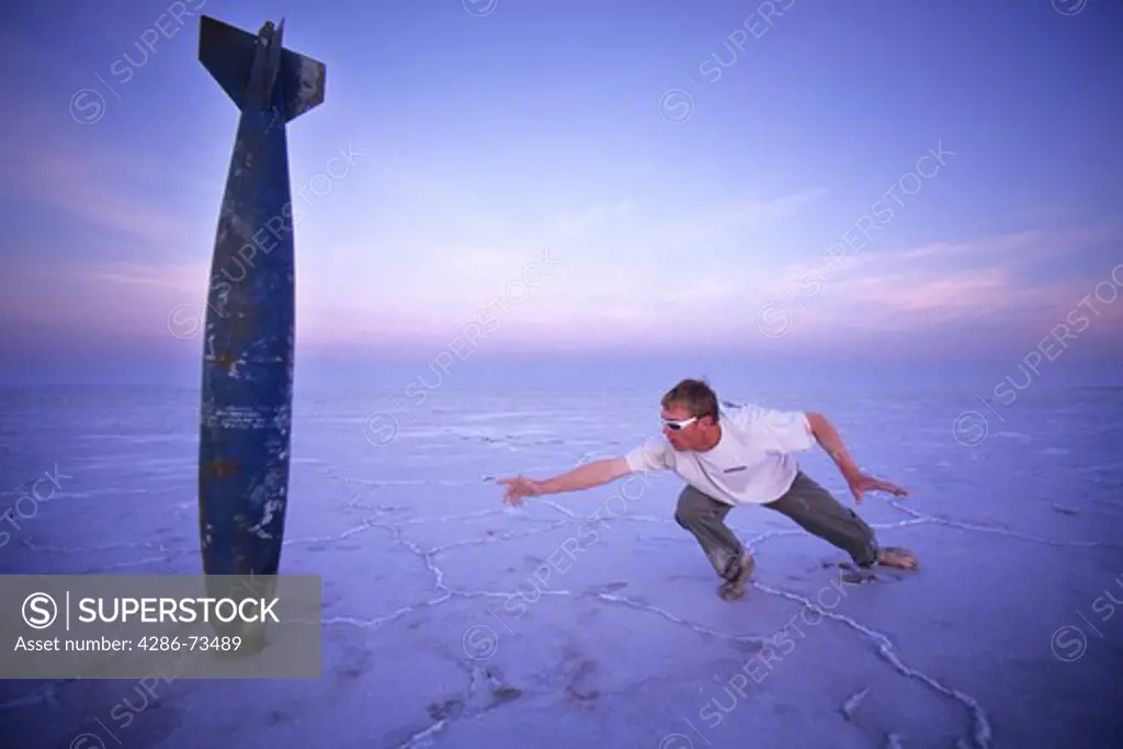 Young man looking at old missile at the Bonneville Salt Flats in Utah, USA