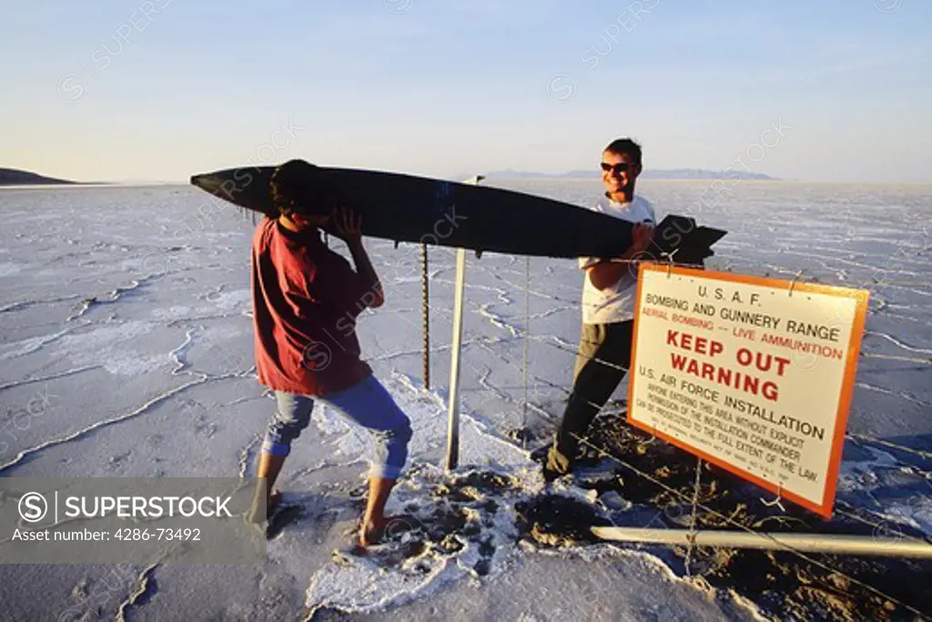 Young men carrying old missile at the Bonneville Salt Flats in Utah, USA