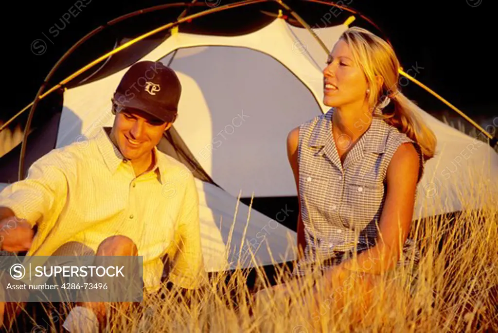 Young couple relaxing near tent on camping trip, Donner Summit near Truckee, California, USA