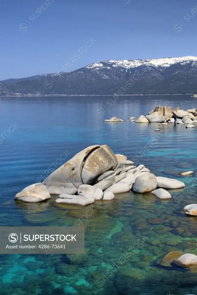 HDR tone mapped Whale rock and snowy mountains on the east shore of Lake Tahoe in the spring