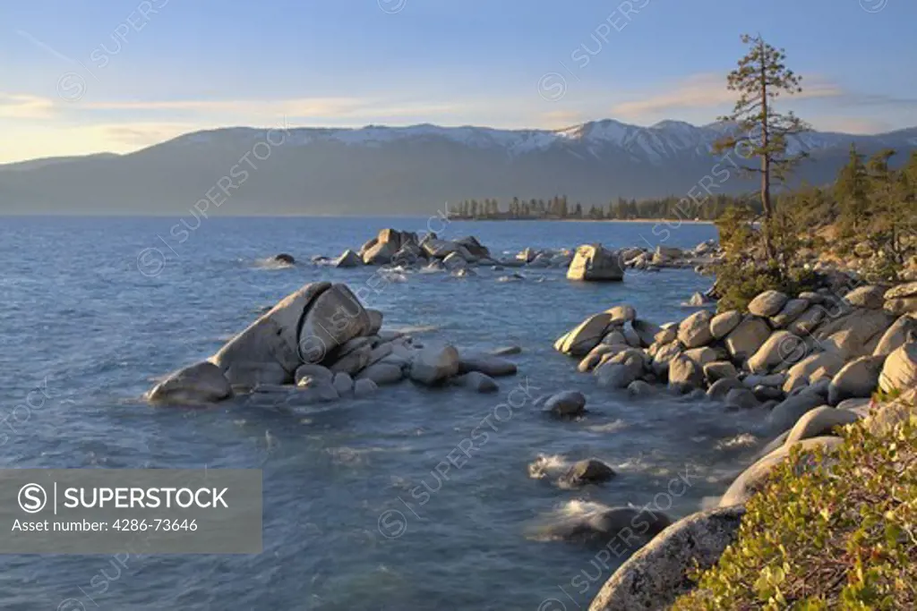 HDR tone mapped Whale rock and snowy mountains on the east shore of Lake Tahoe in the spring