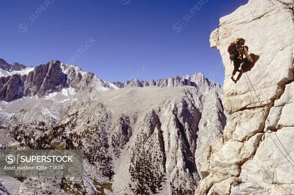 Rock climber climbing rock wall at Lone Pine Peak, California, USA 