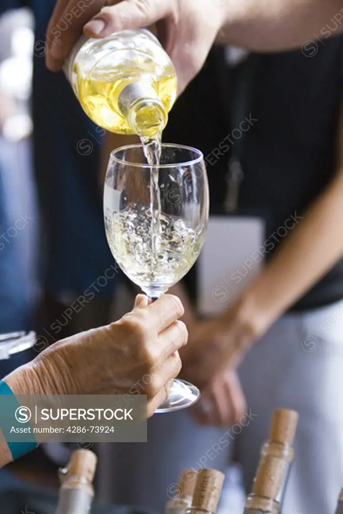 Pouring white wine into a wine glass