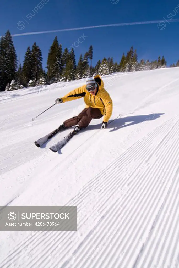 A man alpine skiing on sunny day on freshly groomed snow at Northstar near Lake Tahoe in California