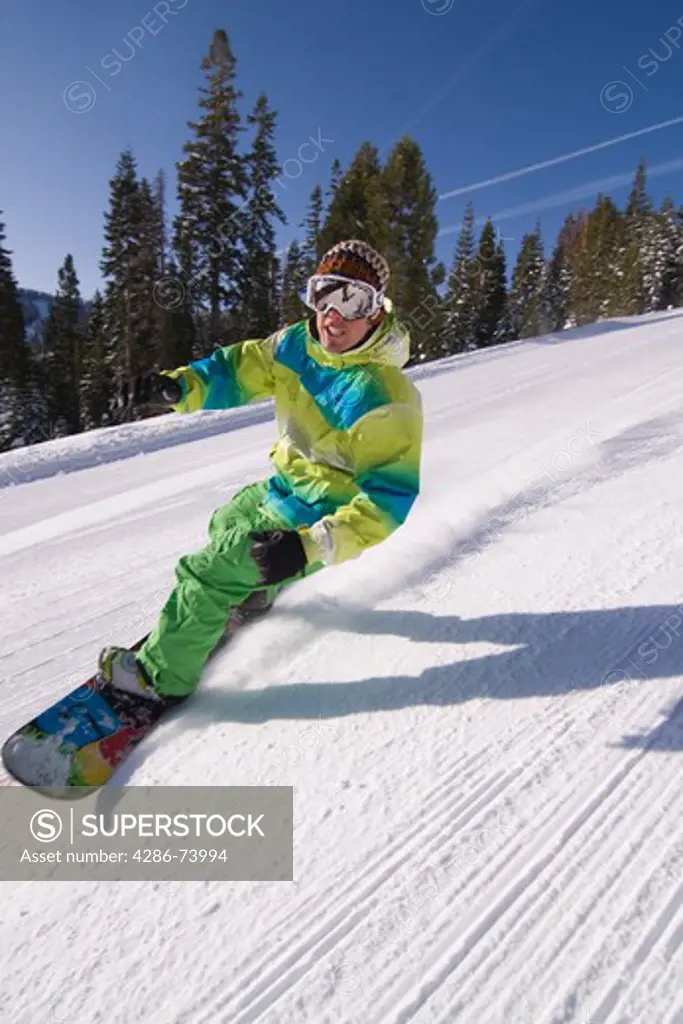 A man snowboarding on a freshly groomed slope on a sunny day at Northstar near Lake Tahoe in California