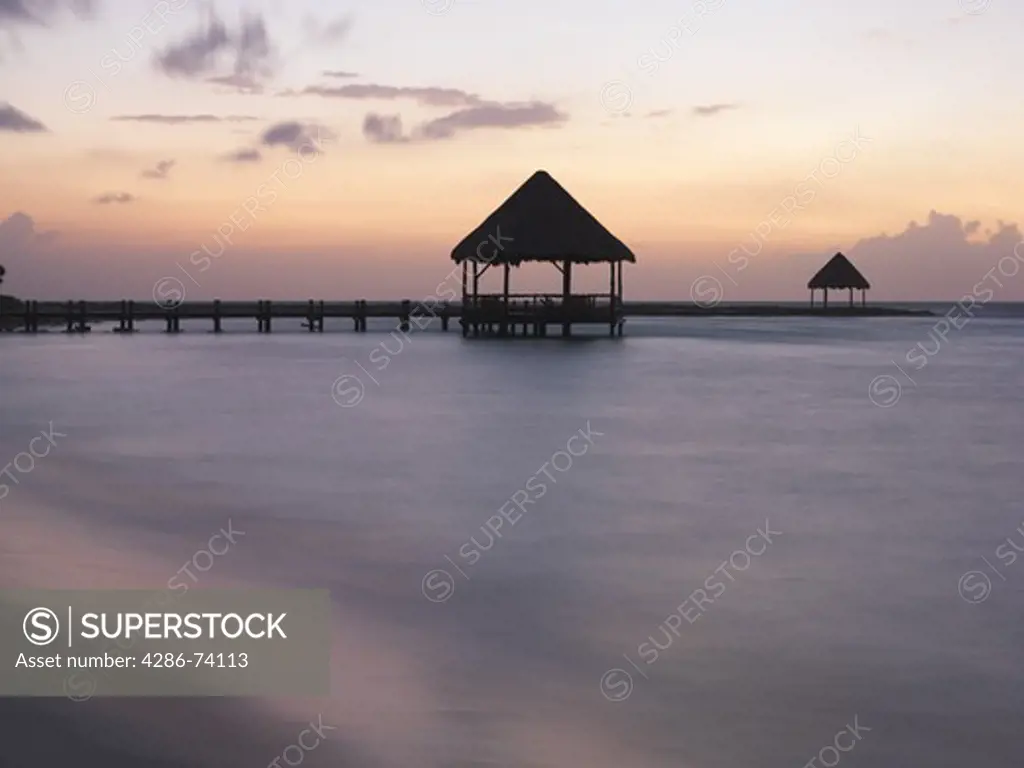 Mexico Quintana Roo Yucatan Peninsula Akumal Mayan Riviera pier with palapa jutting out to the water from the beach