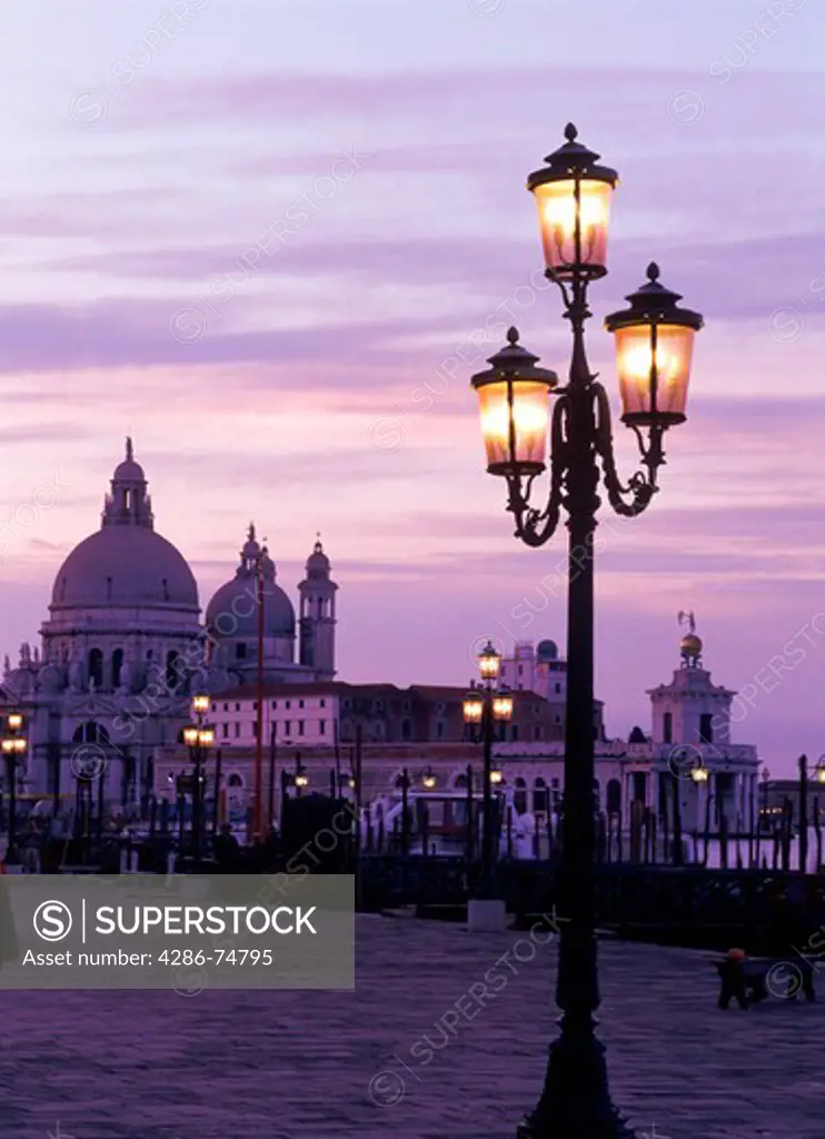Lamps along St Marks Basin with Santa Maria della Salute church at dusk in Venice