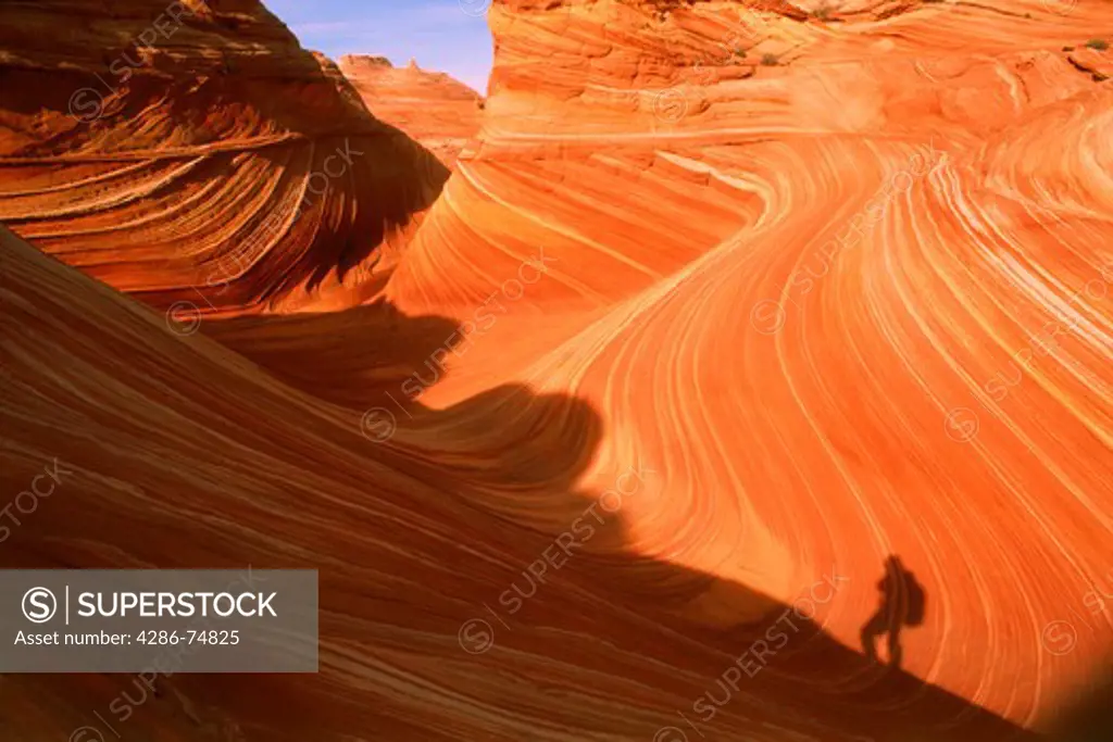 Hiker's shadow against Vermillion Cliffs at Paria Canyon Wilderness in Arizona