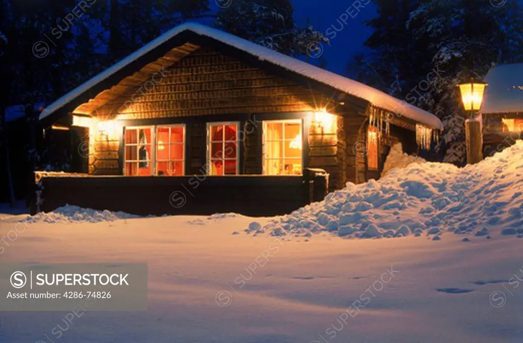 Country cabin under blanket of snow in winter
