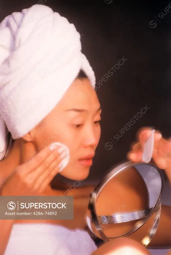 Asian woman using facial clensing pad