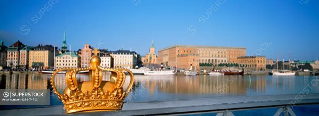 Golden crown on Skeppsholmen Bridge with Royal Palace in Stockholm
