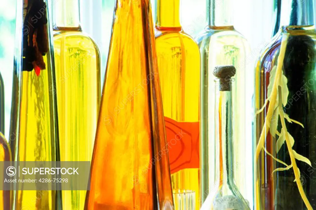 Bottles of various shapes and colors filled with vinegar and oils