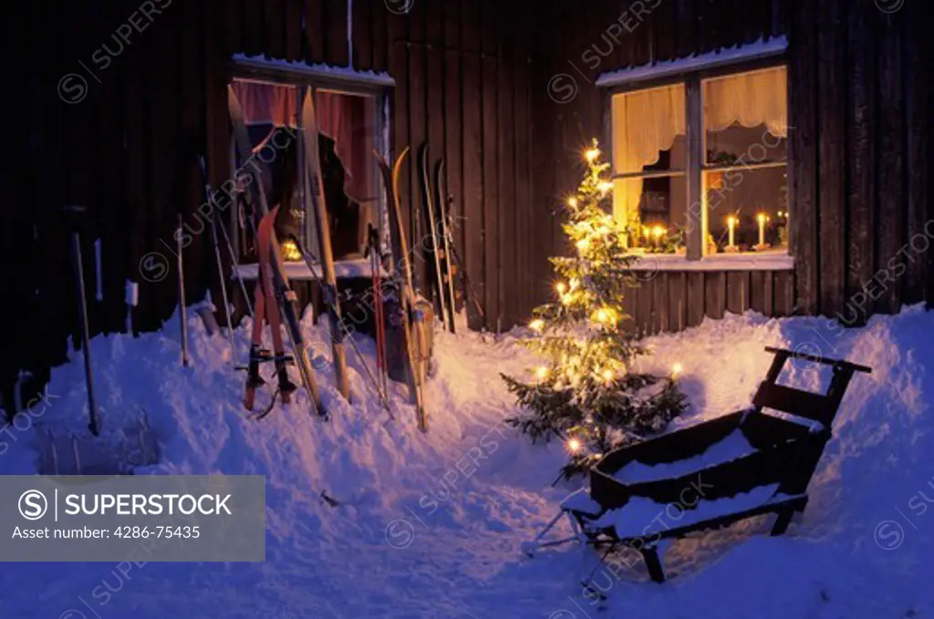 Home in Swedish Lappland above Arctic Circle with skiis, sled, shovel and Christmas tree