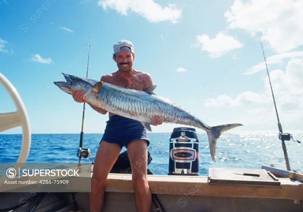 Fisherman holding large Spanish mackerel off Fraser Island in Australia