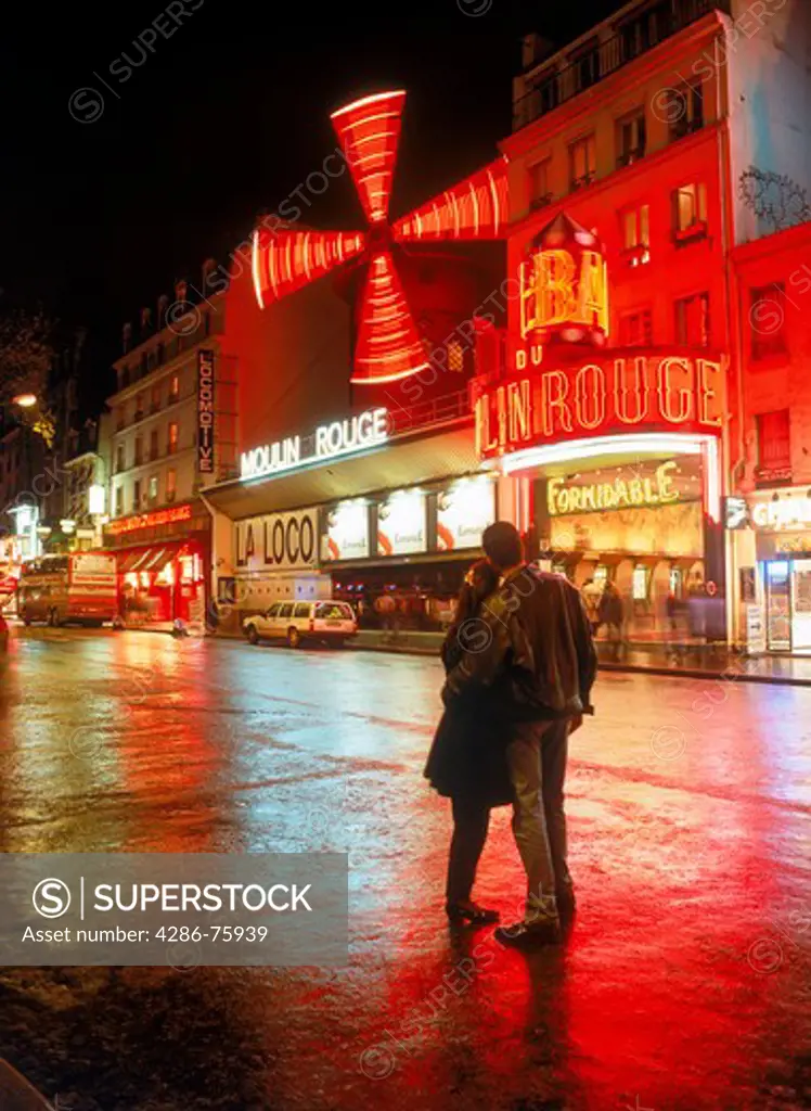 Couple at Moulin Rouge on Blouevard de Clichy after rain in Paris