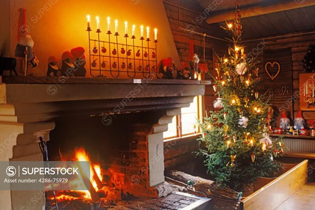 Christmas tree with fireplace and candles during Christmas Season in Scandinavian home