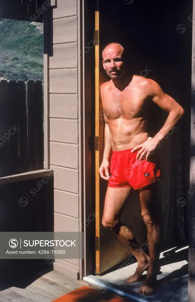 Photographer Chad Ehlers standing outside door of apartment in Laguna Beach, California