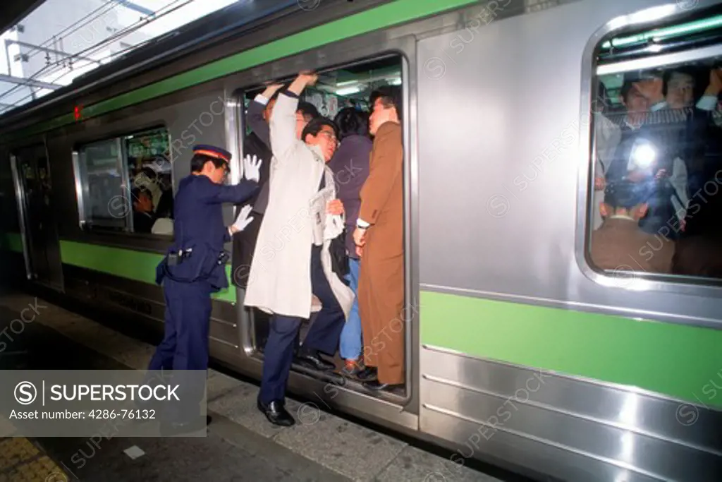 People getting shoved and pushed into subway train door during Tokyo rush hour