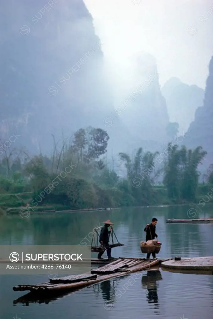 Chinese peasants crossing river near Guilin in Yangshuo Guangxi Province in China under moon mountain peaks