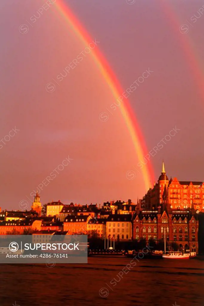 Rainbow over Sodermalm with boats, church and apartment buildings in Stockholm