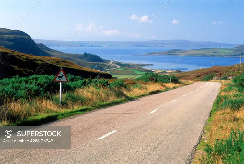 Highway winding along Gruinard Bay and lush hillsides of Scotland