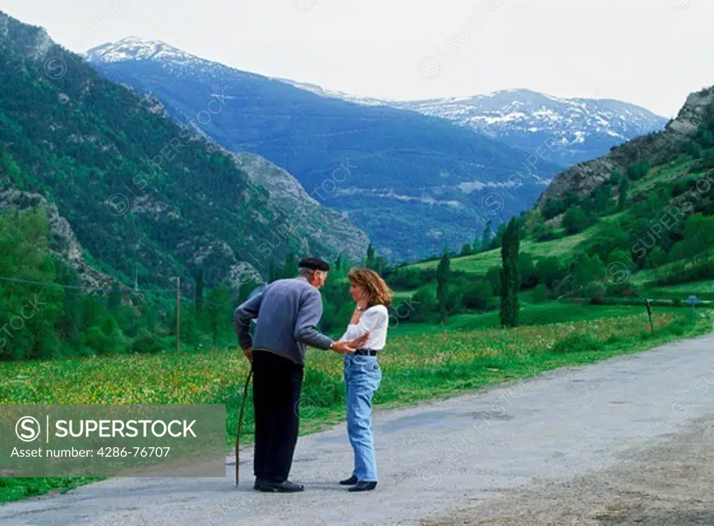 Farmer and young lady talking on country road in Spanish Pyrenees near Andorra