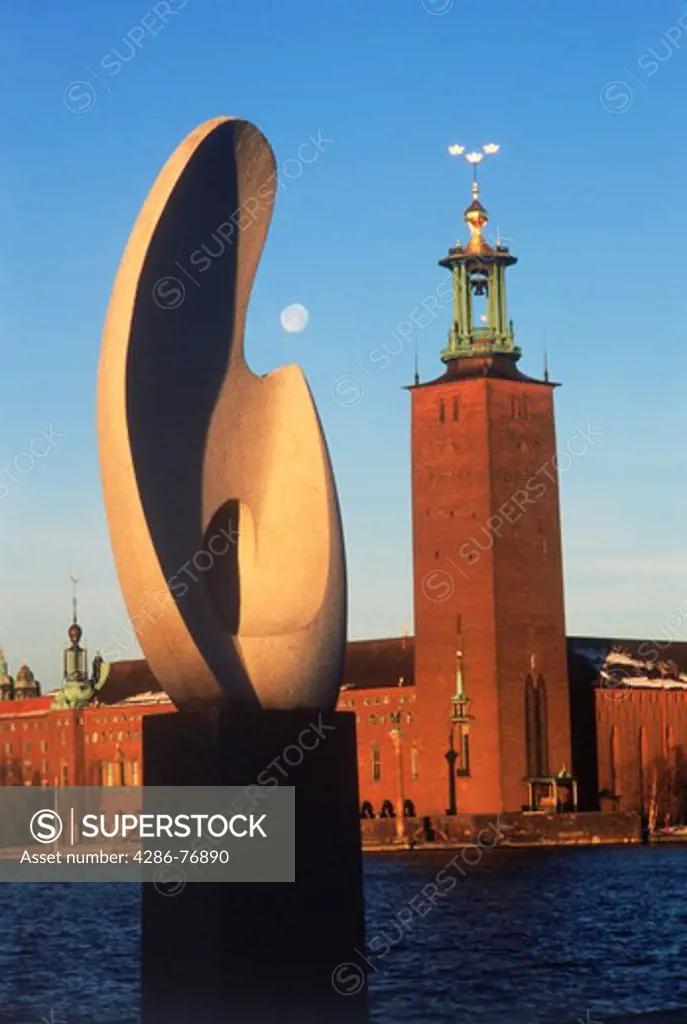 Solboten or Sunboat sculpture at Evert Taubes Terrace on Riddarholmen in Stockholm at sunrise with City Hall (Stadshuset)