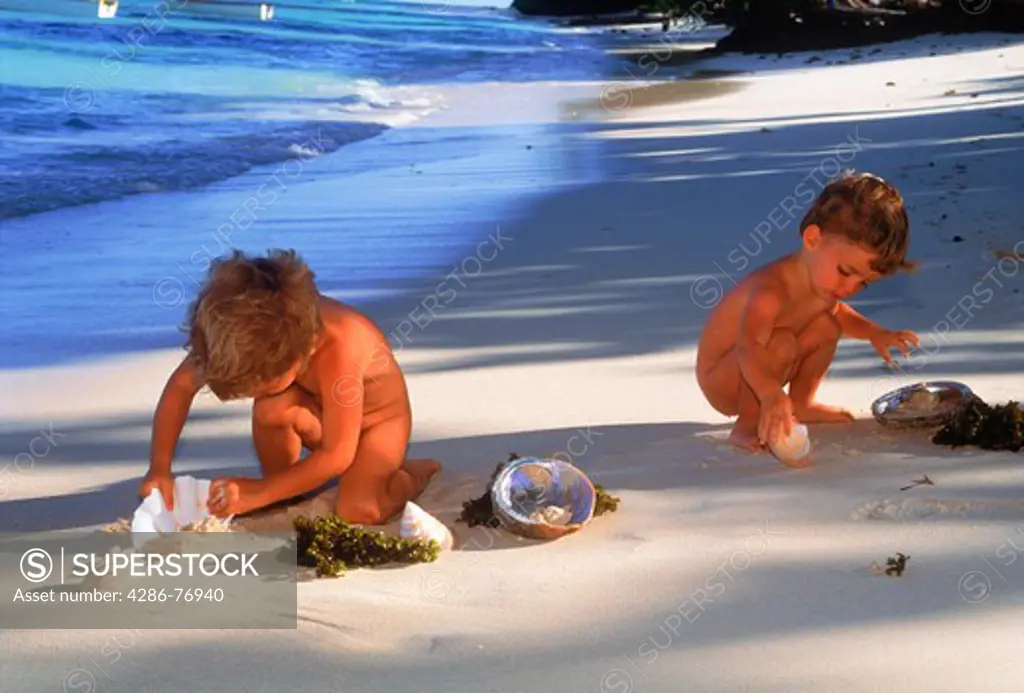 Boy 1-2 years on beach playing with seashells on Mahe Island in Seychelles