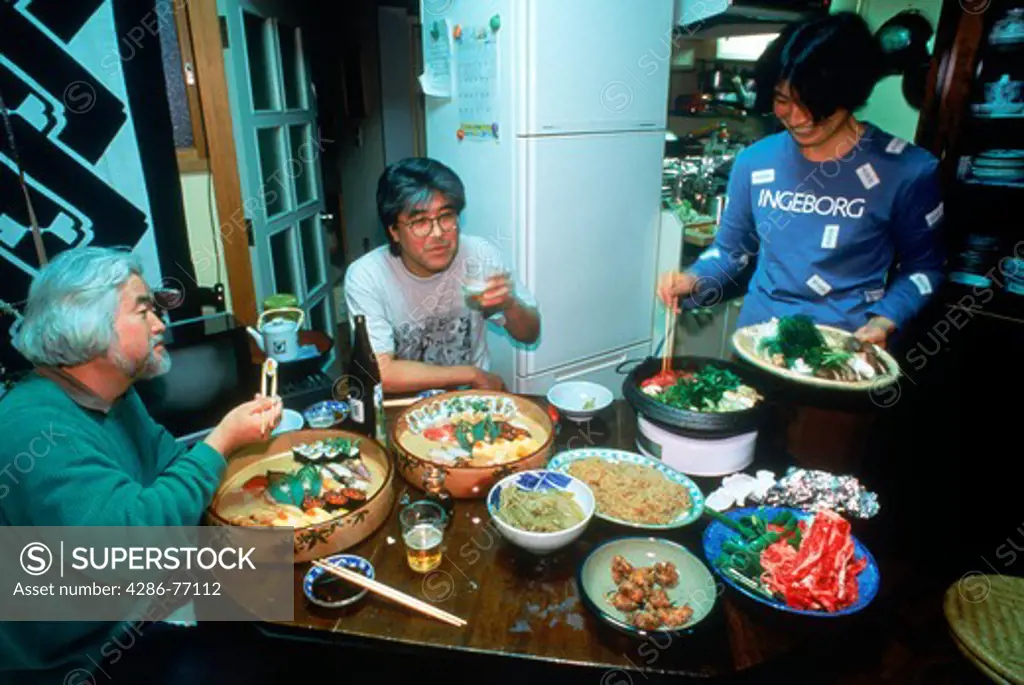 Japanese family eating meal together in typical apartment kitchen