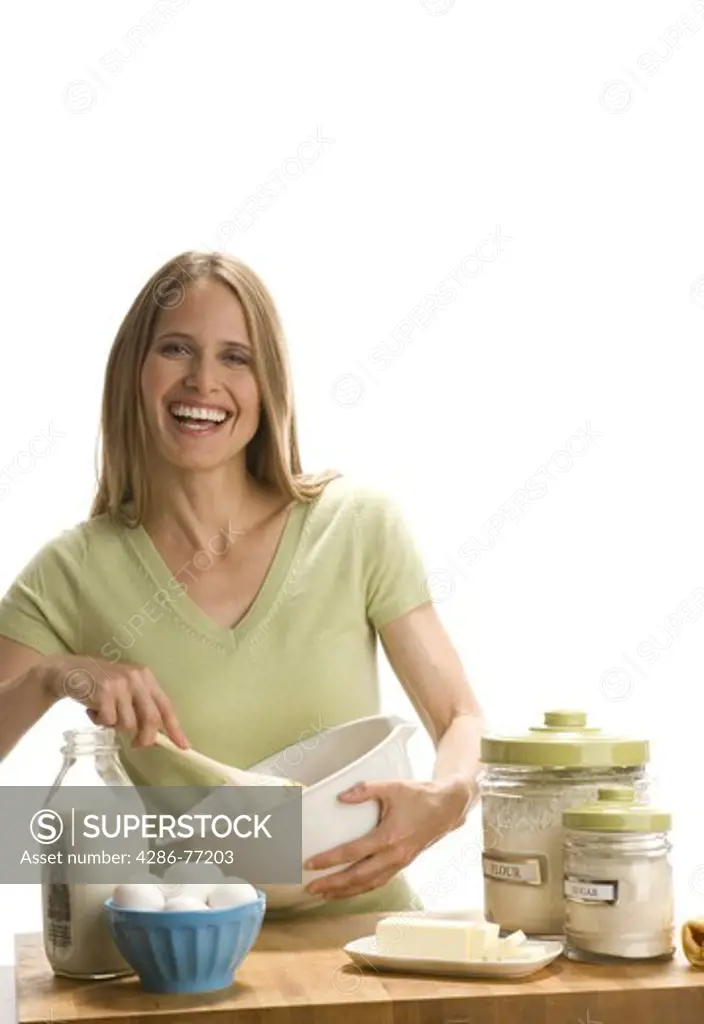 Studio shot of cheerful woman baking in kitchen 