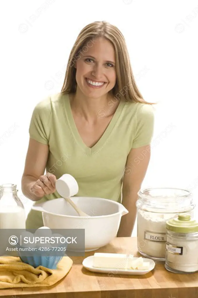 Studio shot of cheerful woman baking in kitchen 