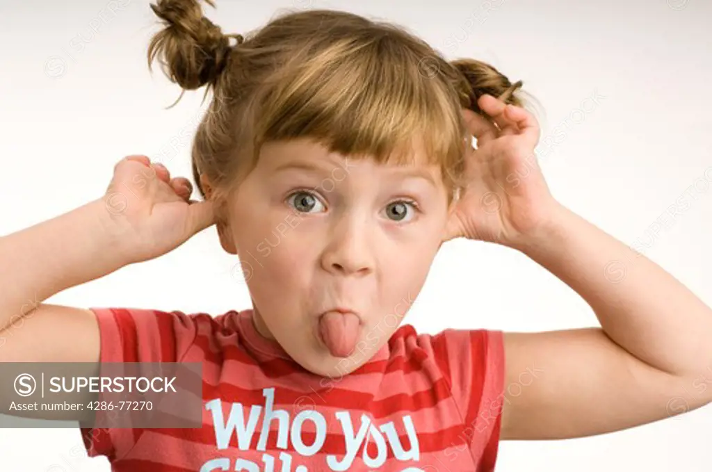 Little girl making a funny face, white background