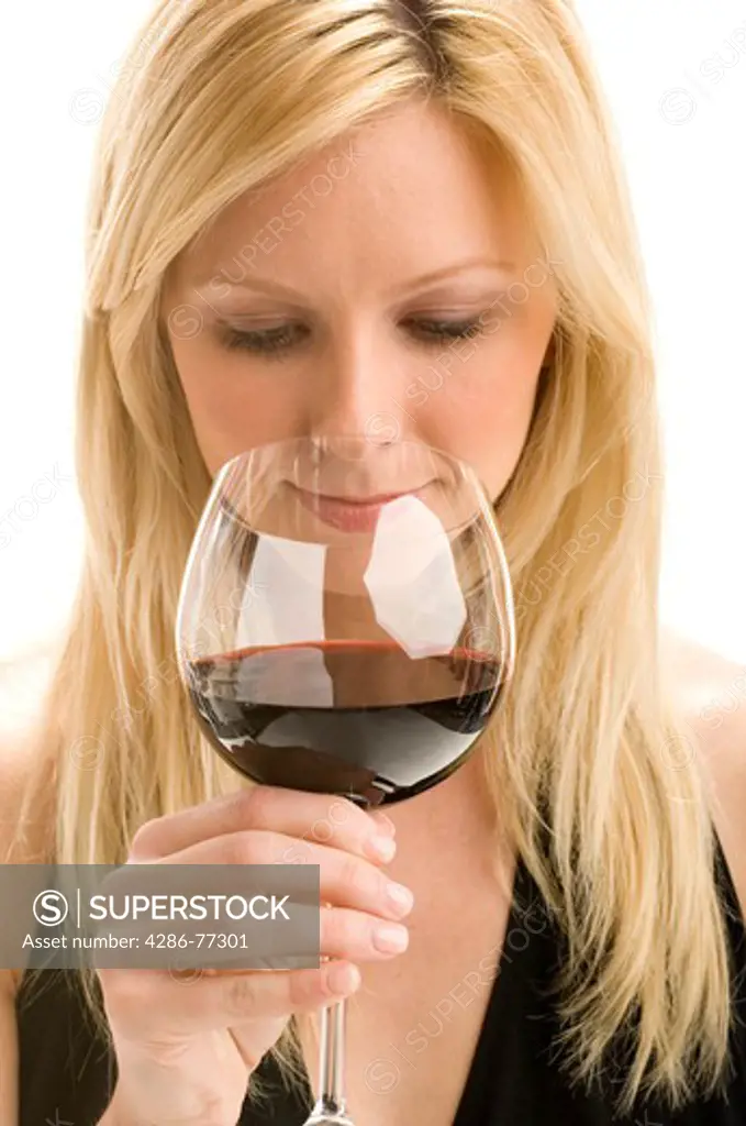 Close-up of an attractive blonde woman sipping on a glass of red wine