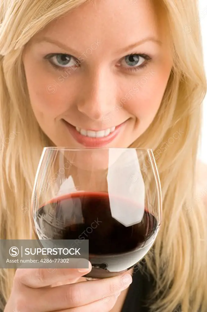 Close-up of an attractive blonde woman holding a glass of red wine